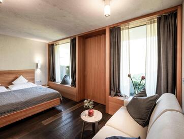 The sleeping area of the Suite Garmisch 1936 with a double bed and a couch