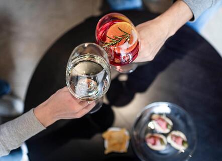 Due persone fanno un brindisi durante l'aperitivo