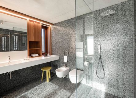 Das moderne und barrierefreie Badezimmer der Ferienwohnungen Cortina 1932 oder Marmolata 1928 mit Waschtisch, Dusche, WC und Bidet