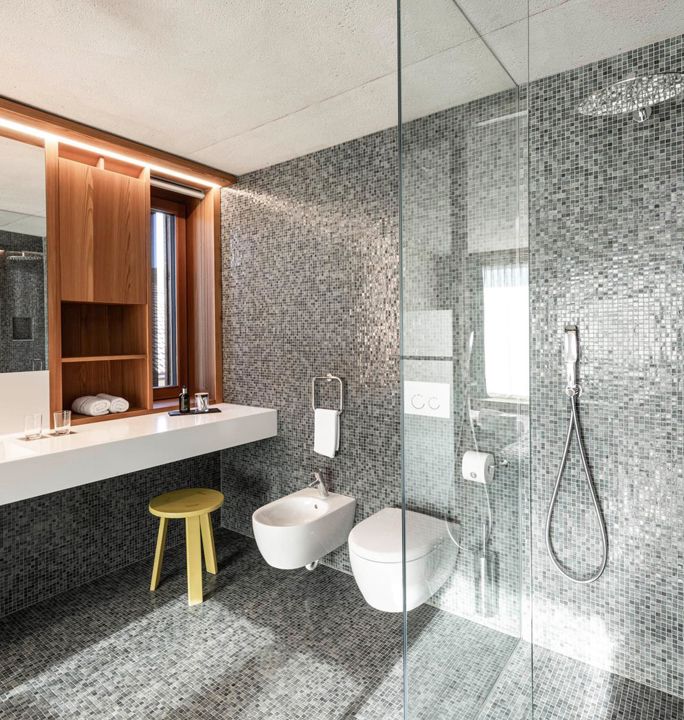 Das moderne und barrierefreie Badezimmer der Ferienwohnungen Cortina 1932 oder Marmolata 1928 mit Waschtisch, Dusche, WC und Bidet