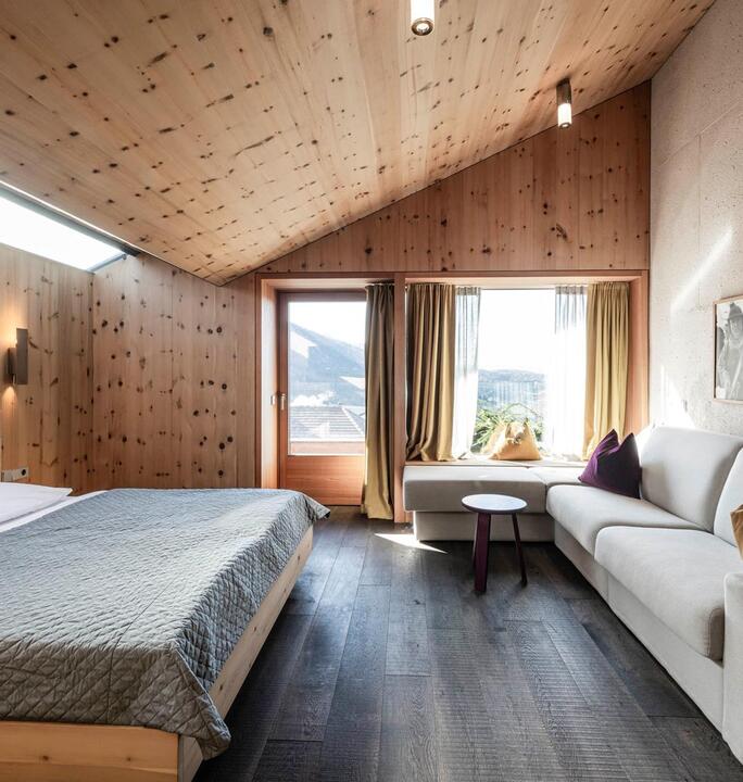 La camera da letto matrimoniale dell'appartamento Santner 1929 con grande divano e balcone